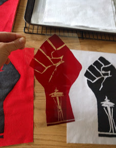 Reproductions of an Occupy Seattle design, hand-cut Rubylith stencil